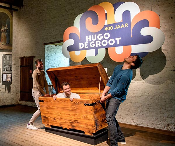 2 mannen en schatkist met man erin 400 jaar hugo de groot
